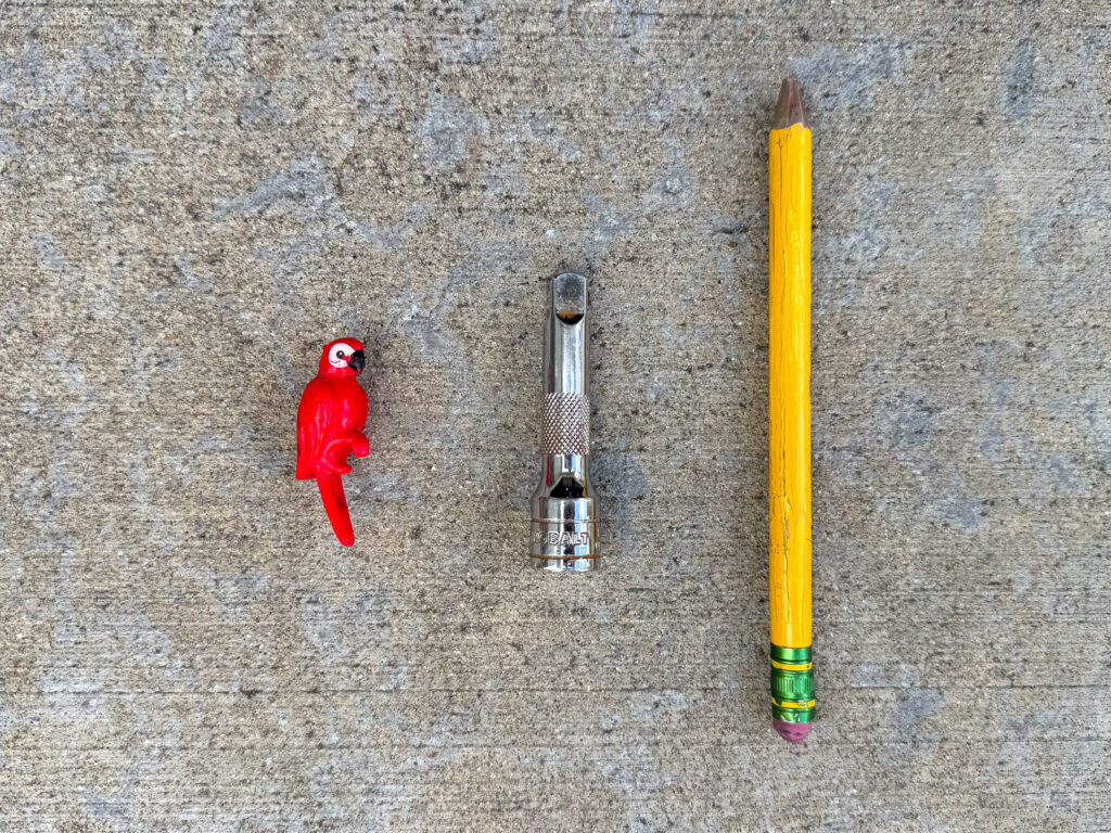 Small red plastic parrot, 3/8" drive socket extension, thick yellow pencil