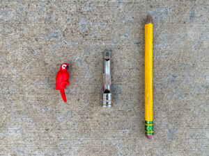 Small red plastic parrot, 3/8" drive socket extension, thick yellow pencil