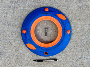 Nerf Sonic Howler Flying Disc, large Phillips-head bolt, and bent mechanical pencil