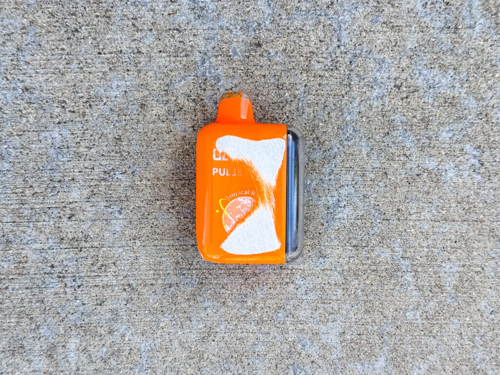 Heavily scuffed orange Geek Bar Pulse Tropical Rainbow Blast vape.