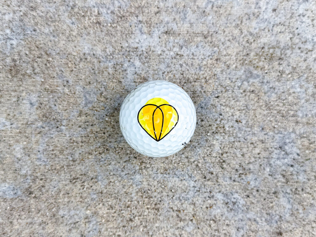 Titleist golf ball with Highstreet Insurance Partners logo featuring overlapping yellow and orange teardrop shapes.