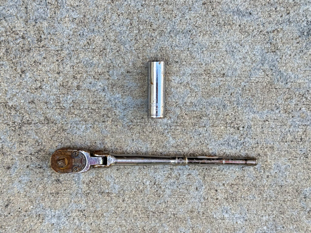 Pittsburg 7/16" deep socket and a rusted and scuffed Snap-on 1/4" drive swivel head ratchet missing its handle.