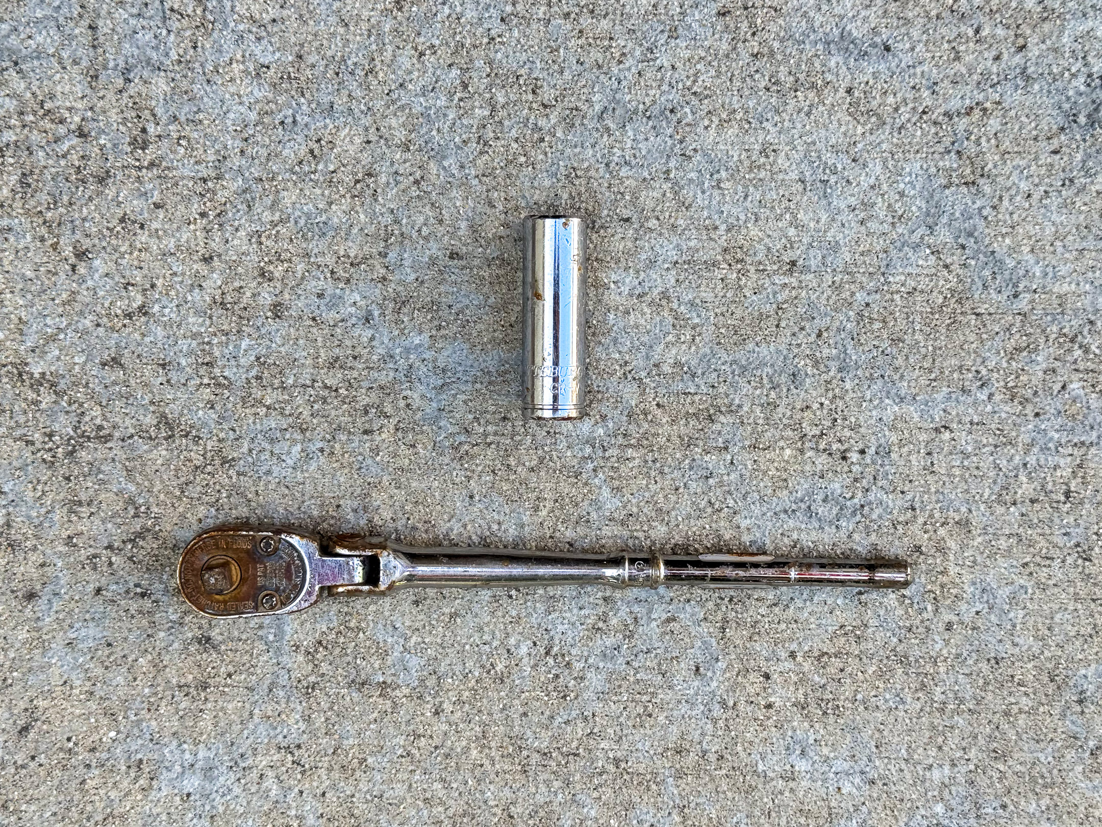 Pittsburg 7/16" deep socket and a rusted and scuffed Snap-on 1/4" drive swivel head ratchet missing its handle.