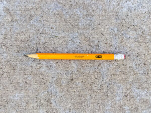A yellow Madisi #2 HB pencil, about one-third used, with a worn eraser and sharpened tip.