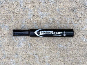 Black permanent marker labeled Marks A Lot Permanent by Avery, lying horizontally with the cap on.