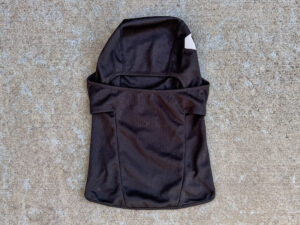 Black Rare Academy Idaho balaclava with a wide horizontal face opening, contoured stitched panels, and part of the white academy logo visible near the upper side.